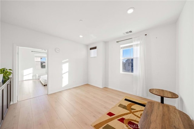 living area with a wealth of natural light and light hardwood / wood-style floors