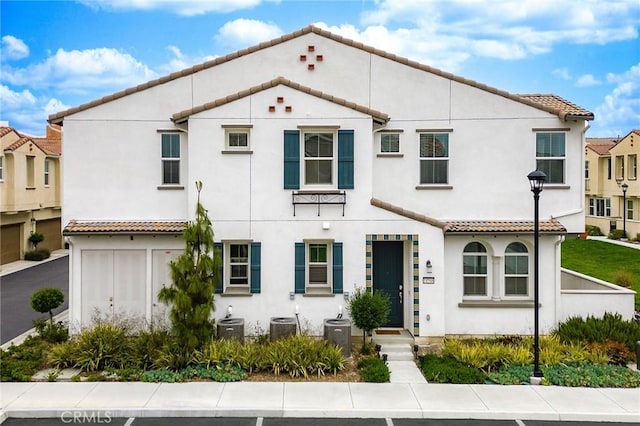 mediterranean / spanish home with cooling unit and a garage