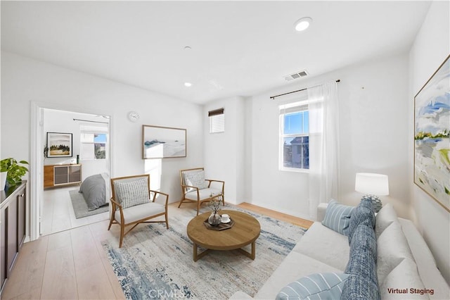 living room featuring a healthy amount of sunlight and light hardwood / wood-style flooring