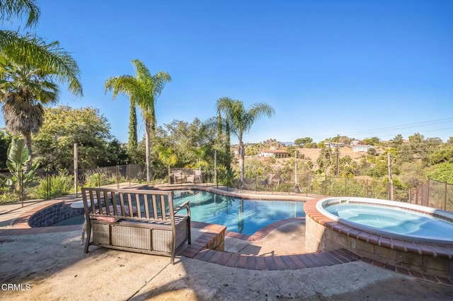 view of swimming pool with an in ground hot tub