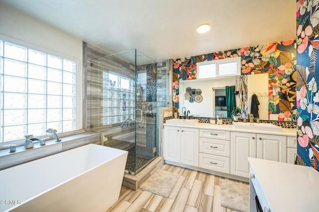 bathroom featuring separate shower and tub, hardwood / wood-style flooring, plenty of natural light, and vanity