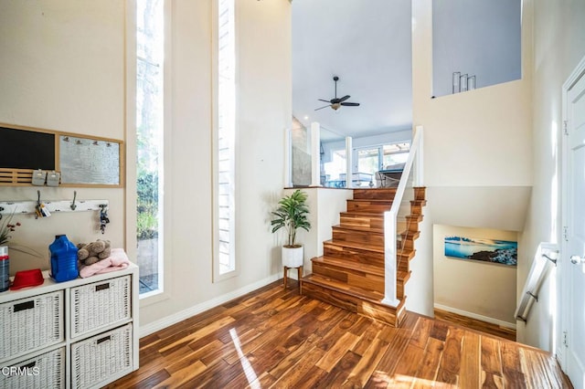 entryway with ceiling fan, dark hardwood / wood-style flooring, and high vaulted ceiling