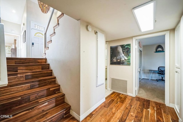 stairway with hardwood / wood-style floors