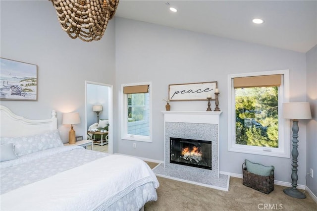 bedroom featuring light carpet, lofted ceiling, and a fireplace