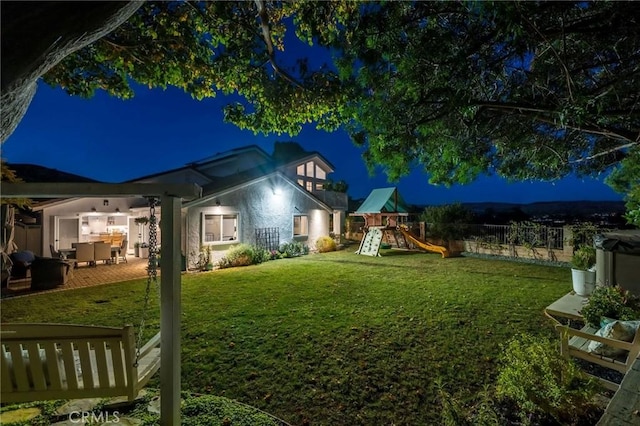 yard at night featuring a playground