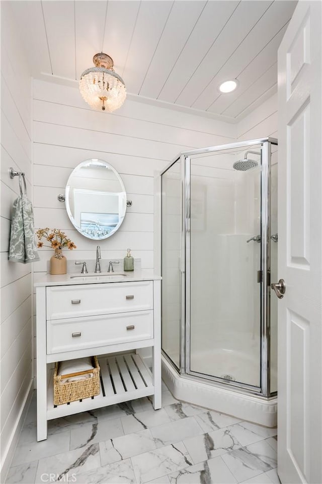 bathroom with vanity, wood walls, and walk in shower