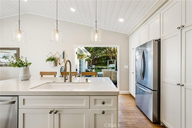 kitchen with wooden ceiling, stainless steel appliances, lofted ceiling, and sink