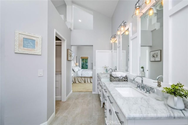 bathroom with high vaulted ceiling, vanity, and a notable chandelier