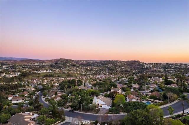 aerial view at dusk featuring a mountain view