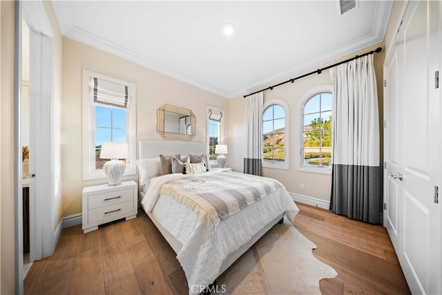 bedroom with crown molding and hardwood / wood-style flooring