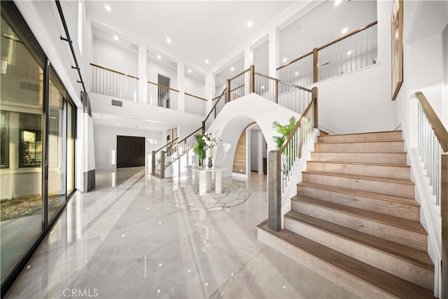 stairs with a towering ceiling and a barn door