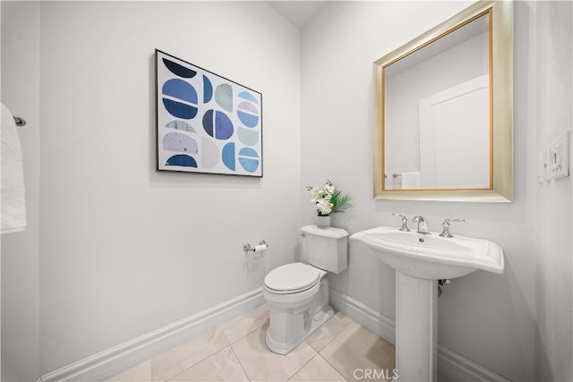 bathroom with toilet, tile patterned flooring, and sink