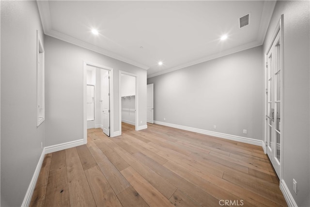 unfurnished bedroom with ornamental molding, light hardwood / wood-style floors, and french doors