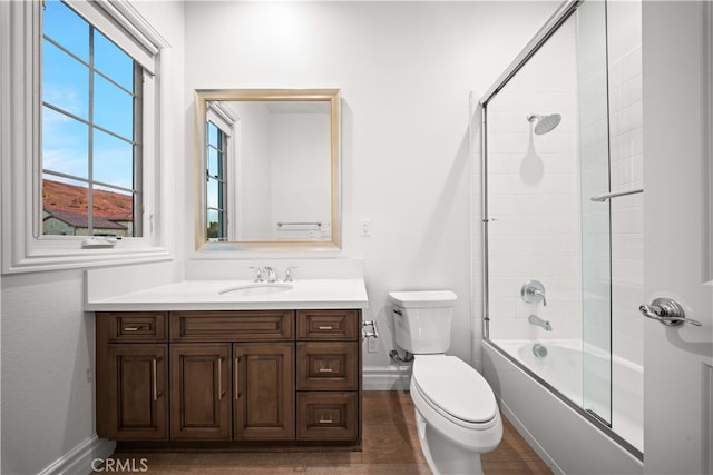 full bathroom with bath / shower combo with glass door, toilet, and vanity