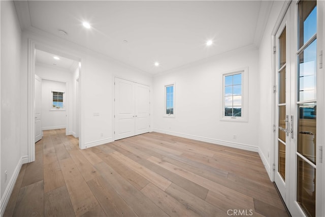 spare room featuring ornamental molding and light hardwood / wood-style floors