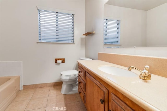 bathroom featuring toilet, vanity, tile patterned flooring, and a tub to relax in