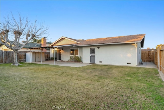 back of house featuring a lawn and a patio