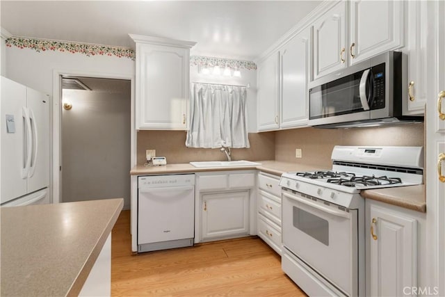 kitchen with white appliances, white cabinetry, and light hardwood / wood-style flooring