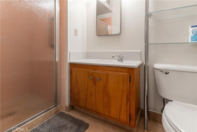 bathroom with toilet, vanity, tile patterned flooring, and walk in shower