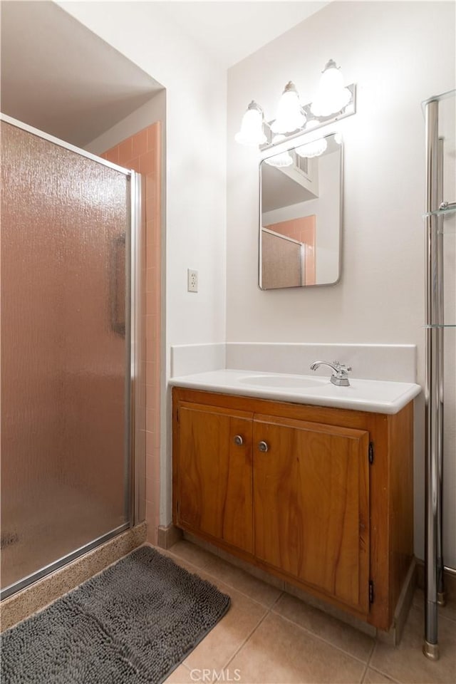 bathroom featuring vanity, tile patterned flooring, and a shower with door