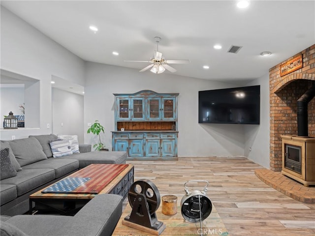 20276 Waco Rd, Apple Valley, CA 92308 - living room with ceiling fan, vaulted ceiling, a wood stove, and light hardwood / wood-style floors