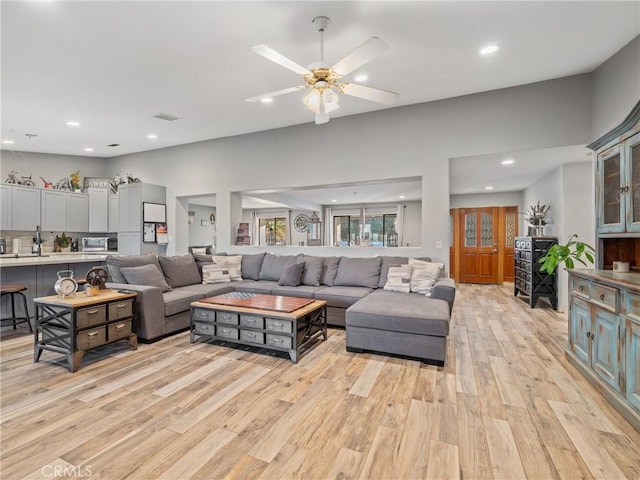 living room featuring ceiling fan and light hardwood / wood-style floors