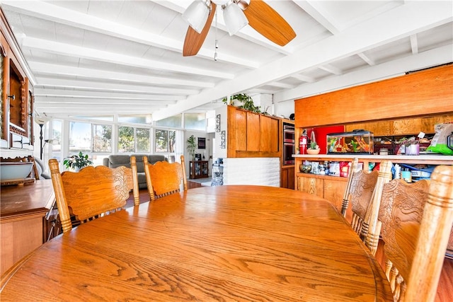 dining space with ceiling fan and beamed ceiling