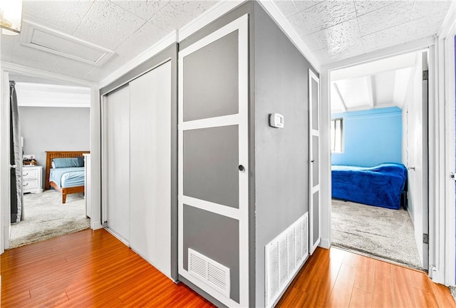 hallway featuring lofted ceiling and hardwood / wood-style floors