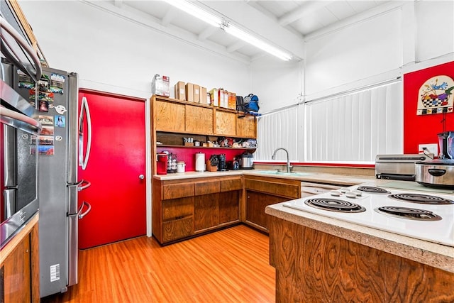 kitchen featuring stainless steel refrigerator, light hardwood / wood-style floors, beamed ceiling, and sink