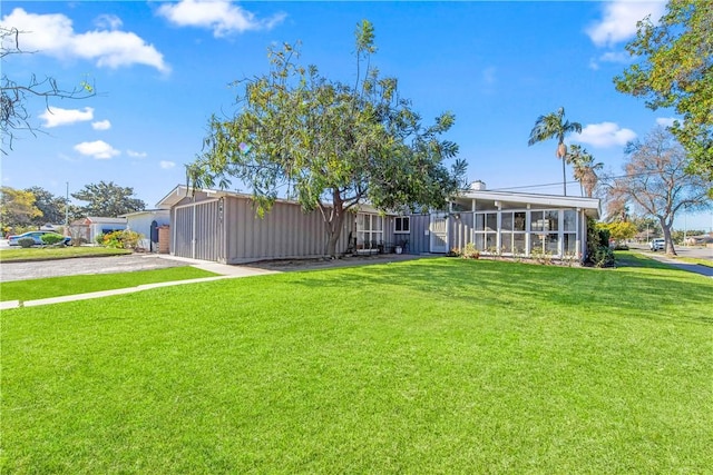 view of front facade with a sunroom and a front yard