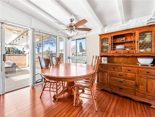 dining area featuring ceiling fan, vaulted ceiling with beams, and light wood-type flooring