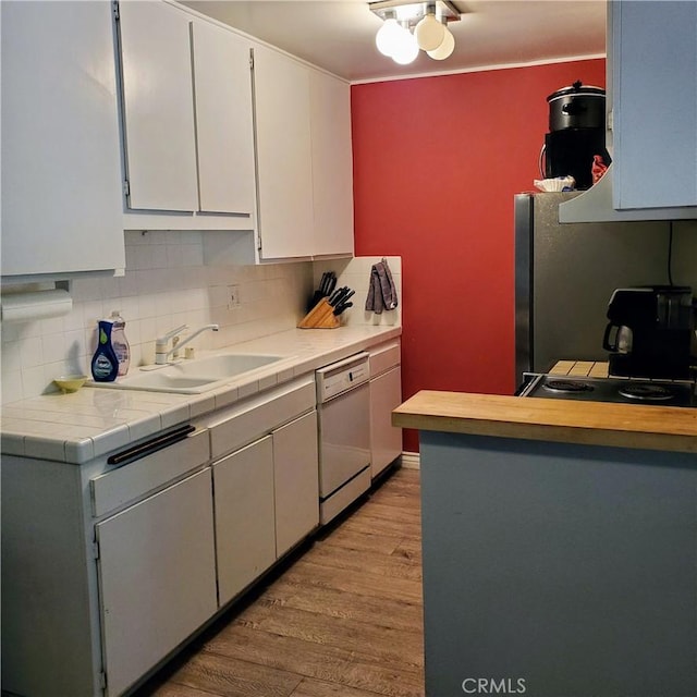 kitchen featuring dishwasher, tasteful backsplash, sink, tile countertops, and light hardwood / wood-style flooring