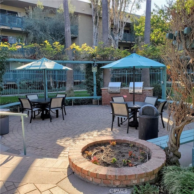 view of patio / terrace with an outdoor fire pit, an outdoor kitchen, and a grill