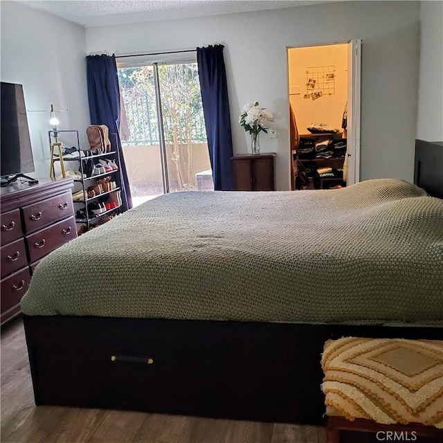 bedroom with access to exterior and wood-type flooring