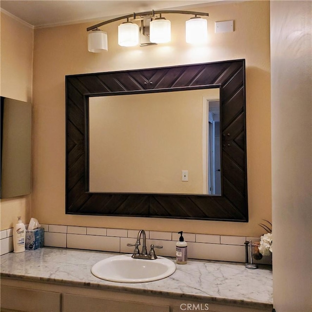 bathroom featuring crown molding, backsplash, and vanity