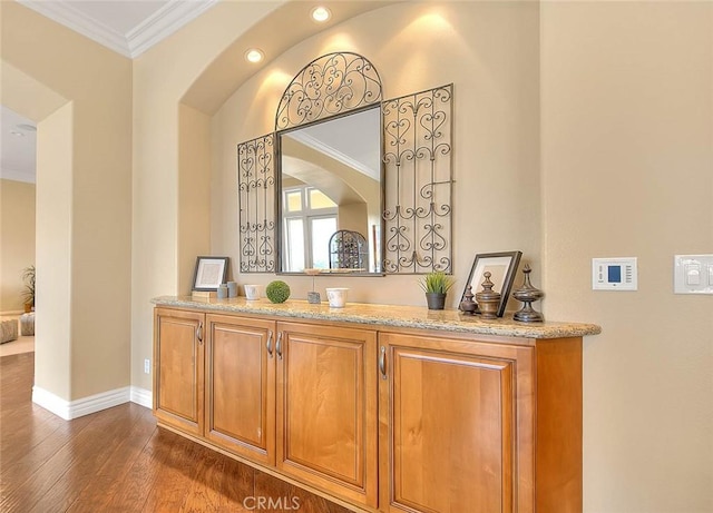 bar featuring crown molding and dark hardwood / wood-style floors