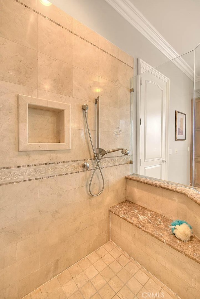 bathroom featuring tile patterned floors, ornamental molding, and a tile shower