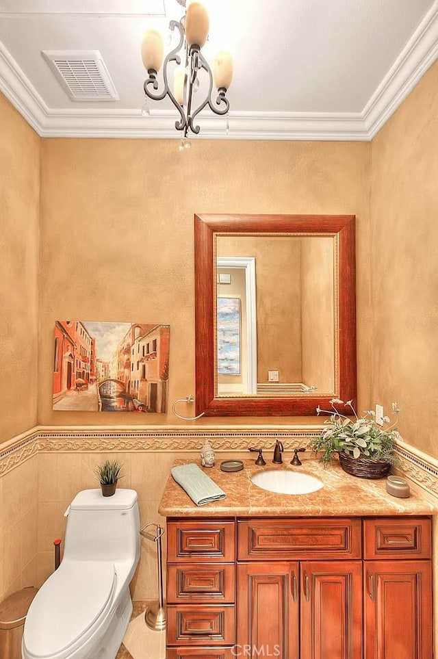 bathroom with ornamental molding, vanity, a chandelier, and toilet