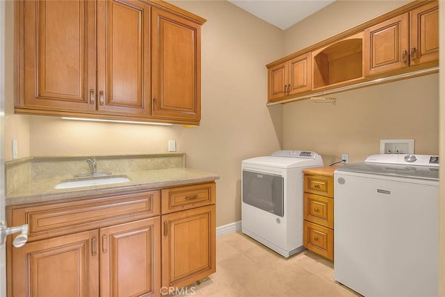 washroom featuring cabinets, sink, and independent washer and dryer