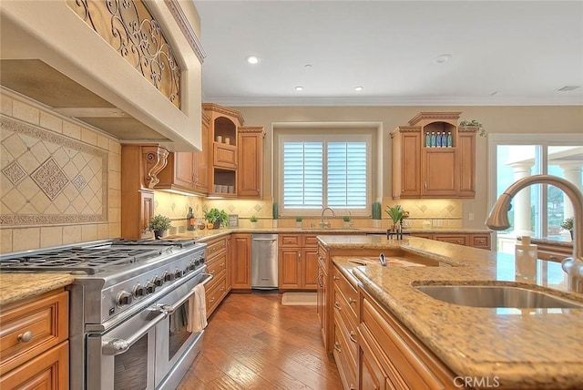 kitchen featuring sink, crown molding, light stone counters, custom range hood, and range with two ovens