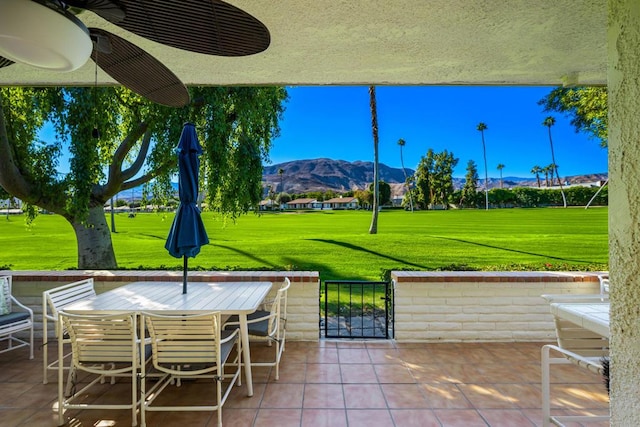 view of patio with an outdoor bar, ceiling fan, and a mountain view