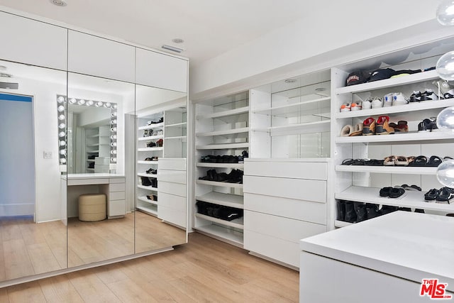 walk in closet with light wood-type flooring