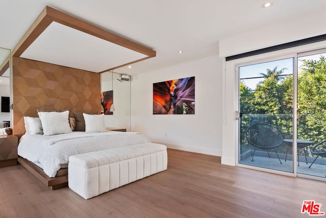 bedroom featuring wood-type flooring and access to exterior