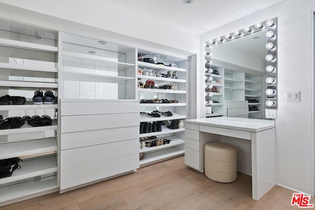 walk in closet with light hardwood / wood-style flooring