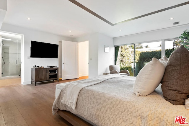 bedroom featuring ensuite bath and light hardwood / wood-style floors