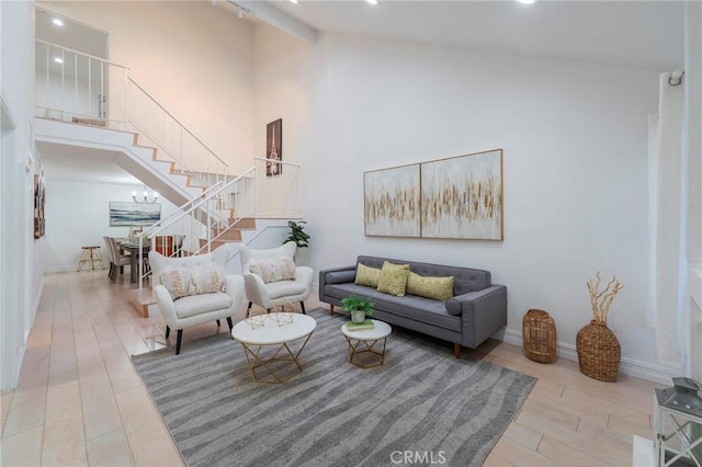 living room with beam ceiling, a notable chandelier, and high vaulted ceiling