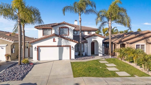 mediterranean / spanish house featuring a front yard and a garage