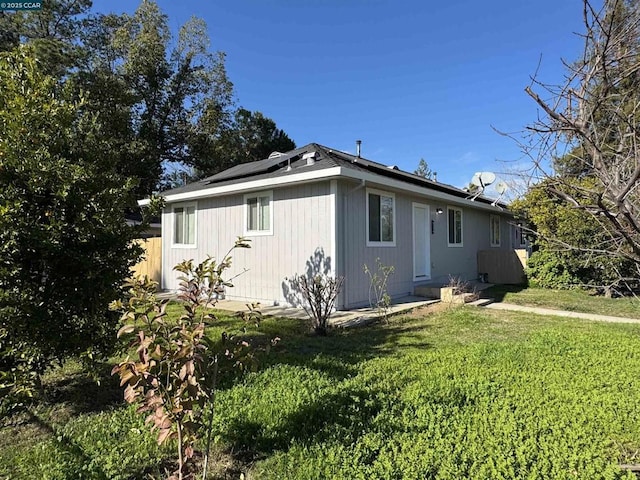 view of property exterior featuring a lawn and solar panels