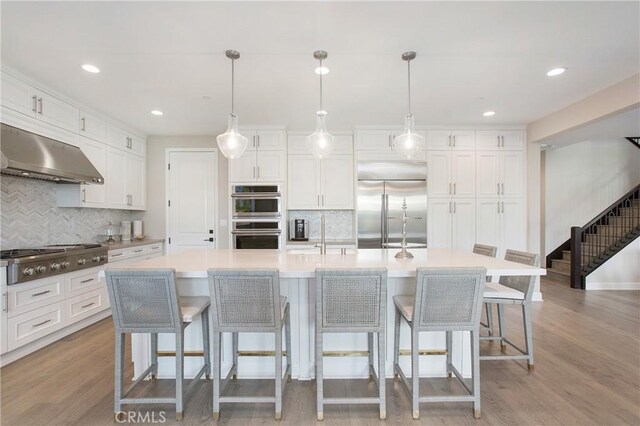 kitchen featuring decorative light fixtures, stainless steel appliances, and a large island