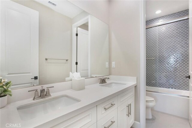 full bathroom featuring combined bath / shower with glass door, vanity, tile patterned flooring, and toilet